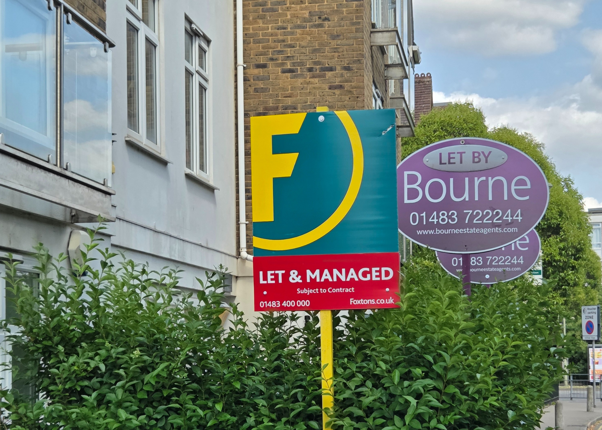 Close of letting agent boards outside a block of flats.