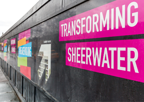 Image of a site hoarding branded with the words Transforming Sheerwater.