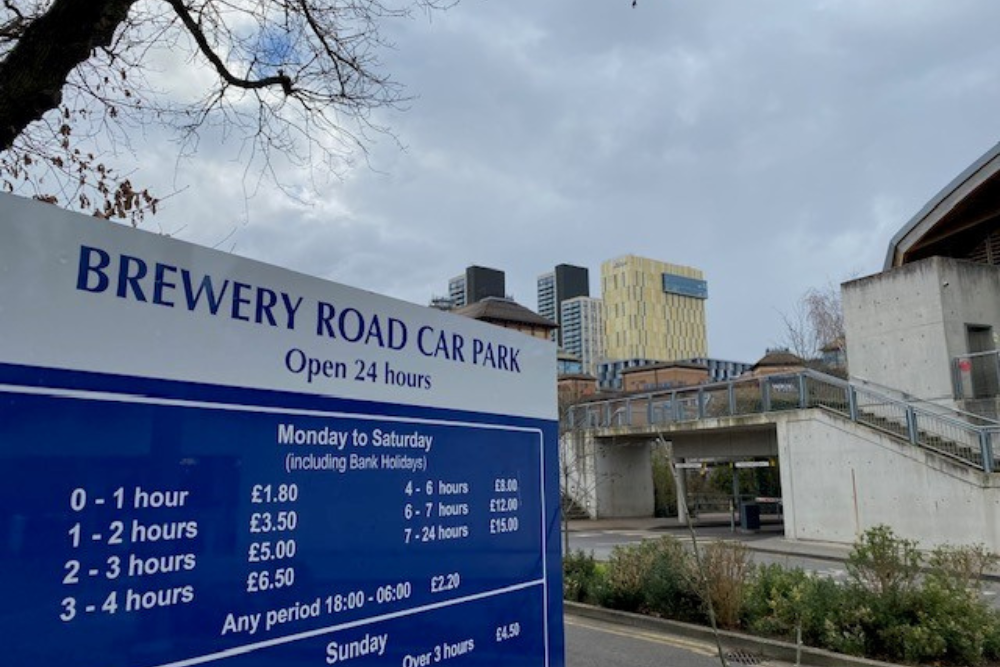 Brewery Road car park exterior with car park sign in the front and Woking skyline in the background