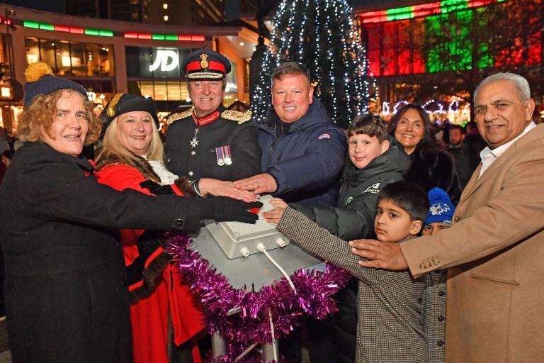 Leader of the Council, Mayor of Woking, His Majesty's Lord-Lieutenant, Boz and representatives from the Woking Asian Business Forum pressing a button with Woking's Christmas tree lit up behind them