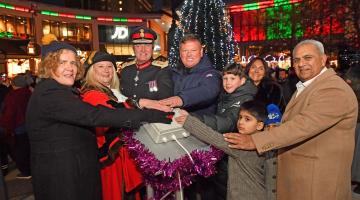Leader of the Council, Mayor of Woking, His Majesty's Lord-Lieutenant, Boz and representatives from the Woking Asian Business Forum pressing a button with Woking's Christmas tree lit up behind them